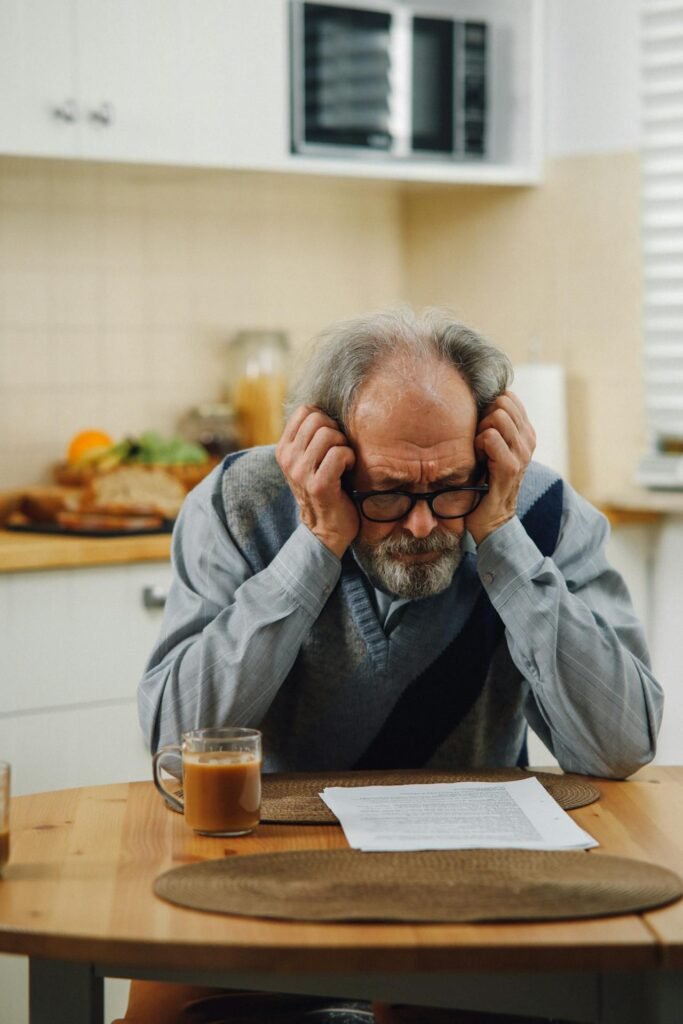 A parent sitting in a doctor’s office, holding paperwork and looking emotional after receiving an autism diagnosis for their child.