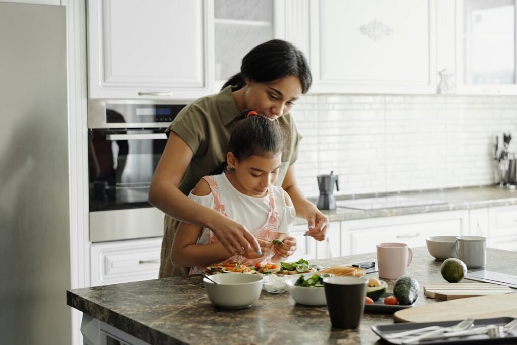 a child helping to cook in the kitchen.