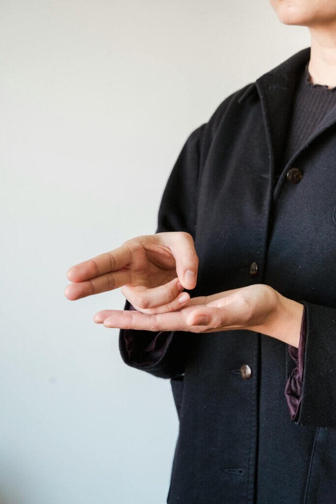 A person using sign language representing nonverbal autistic individuals using communication method