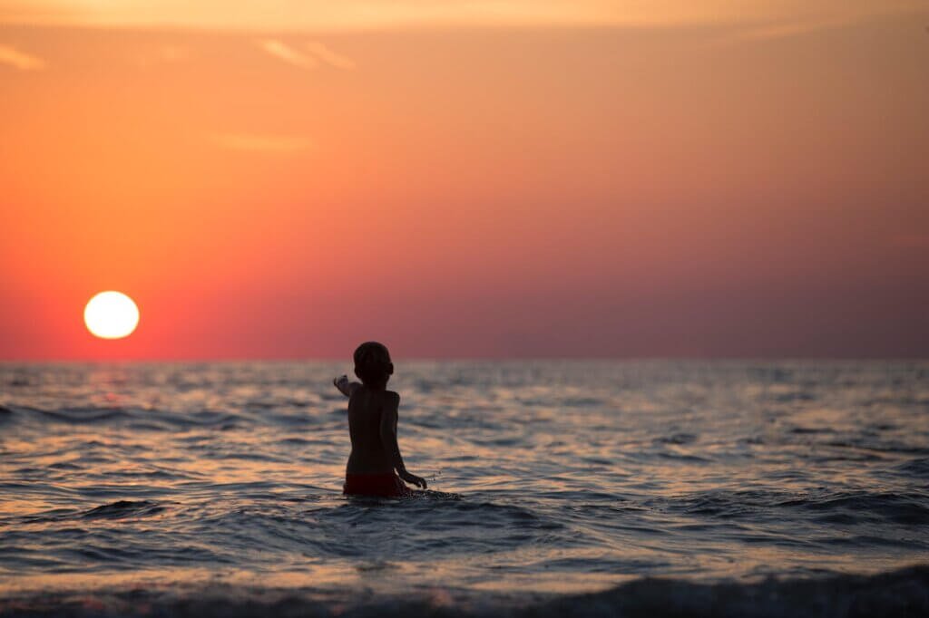 Nonverbal autistic child pointing to sunrise representing hope